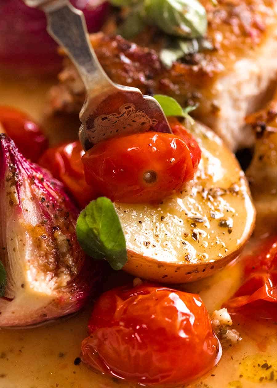 关闭摘起蕃茄和土豆的叉子从地中海鸡和土豆烘烤gydF4y2Ba