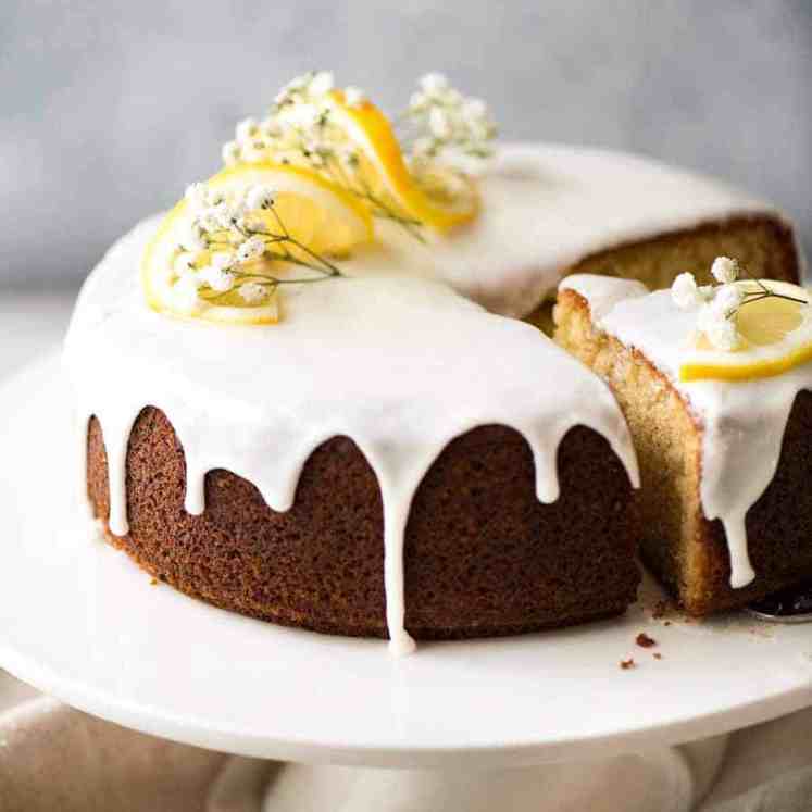 柠檬蛋糕淋上柠檬汁，装饰上柠檬片和花，放在白色蛋糕盘上，切下一块gydF4y2Ba