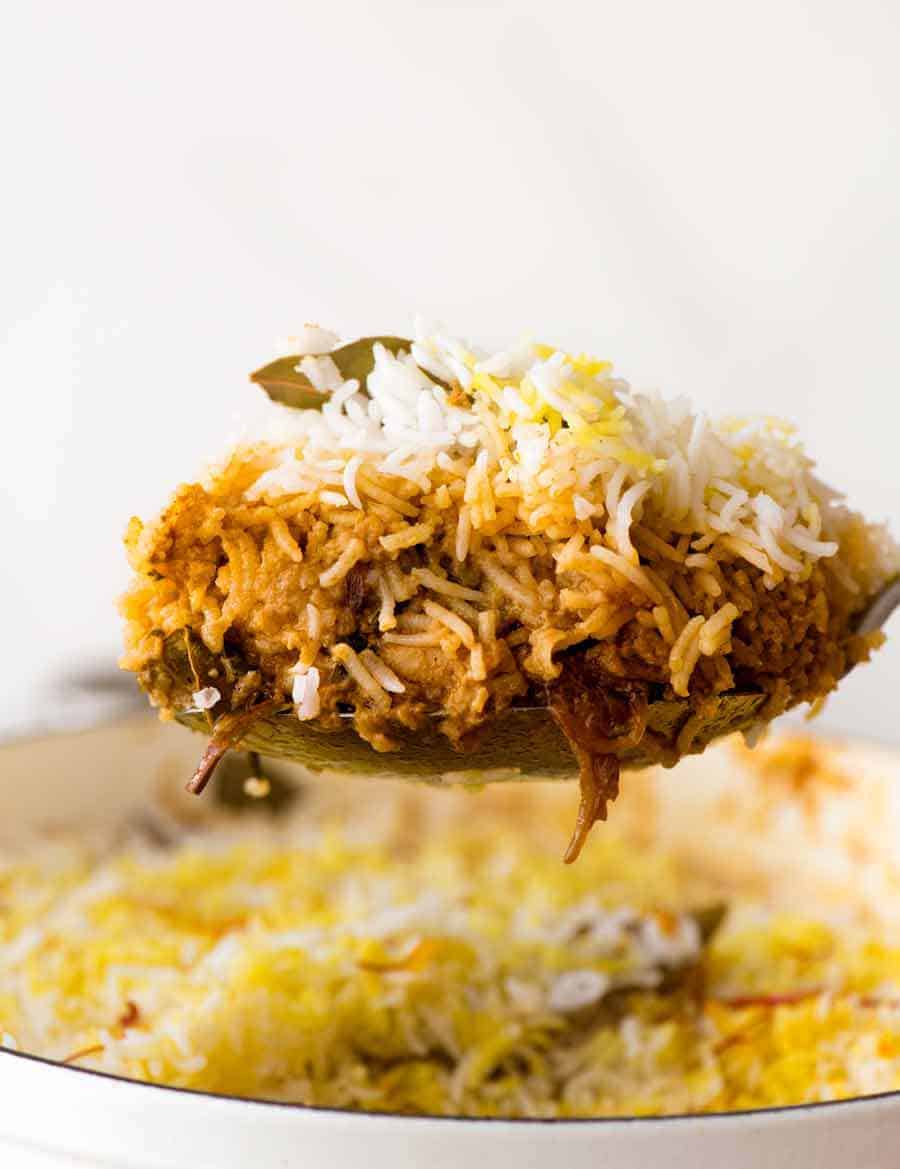 从白锅提供鸡Biryani，显示鸡肉咖喱和米饭