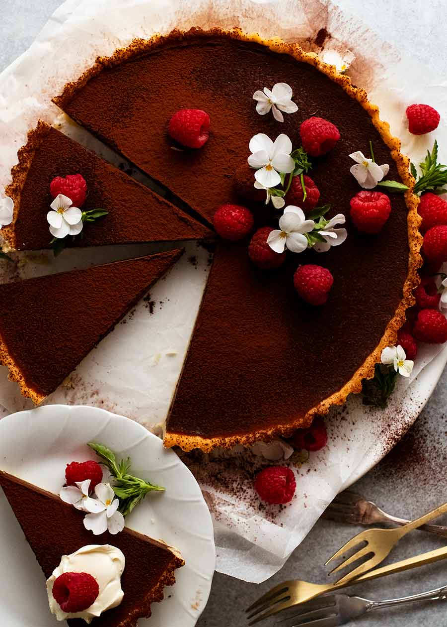 用莓和可食的花装饰的巧克力馅饼顶上的照片GydF4y2Ba